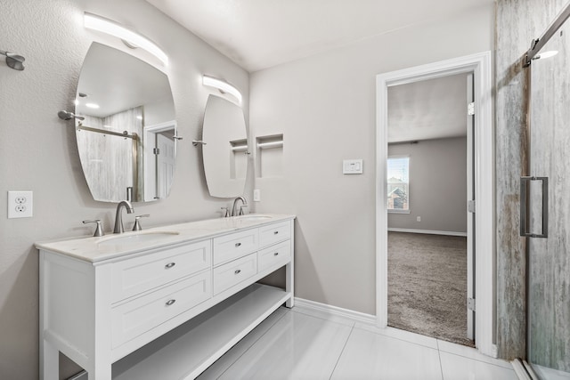 full bathroom with a stall shower, a sink, baseboards, and double vanity