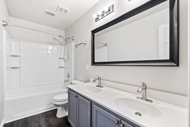 bathroom with toilet, visible vents, a sink, and wood finished floors