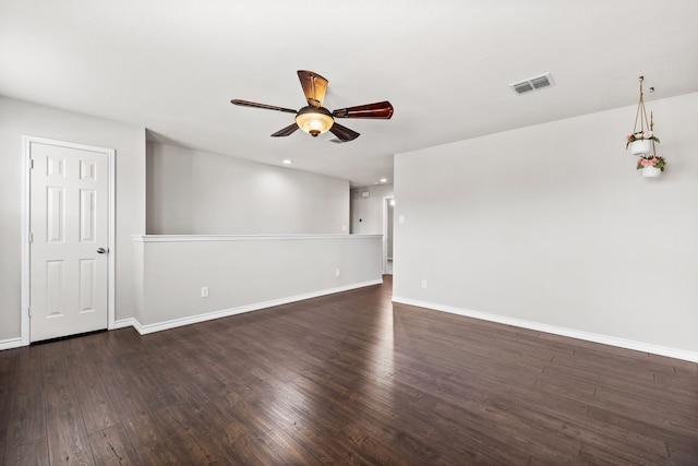 unfurnished room featuring visible vents, dark wood finished floors, baseboards, and ceiling fan