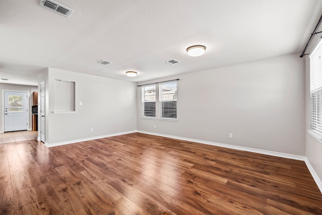 unfurnished room with visible vents, baseboards, and wood finished floors