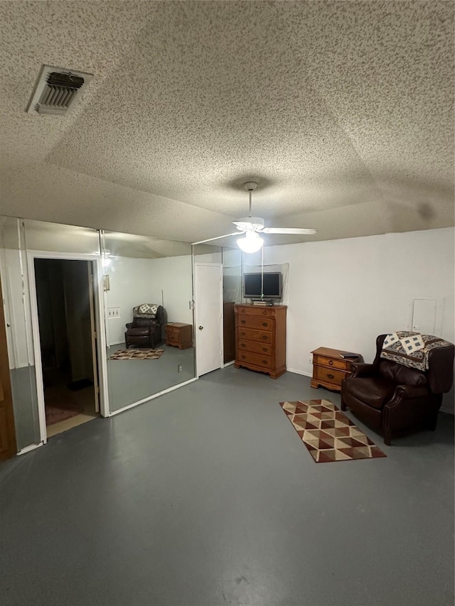 unfurnished room with ceiling fan, concrete floors, and a textured ceiling