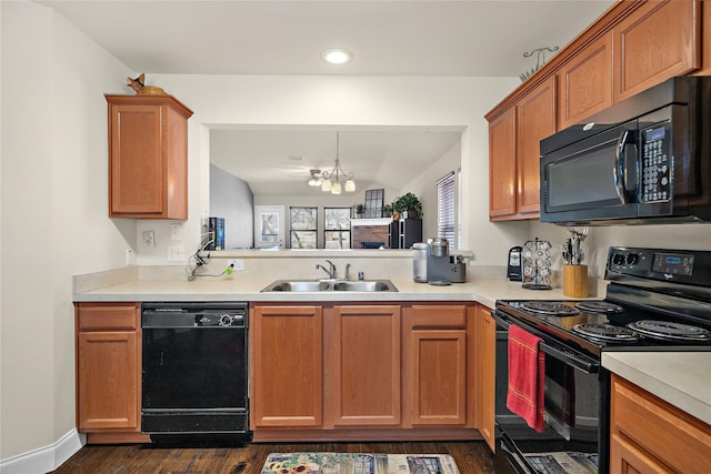 kitchen with an inviting chandelier, sink, dark wood-type flooring, and black appliances