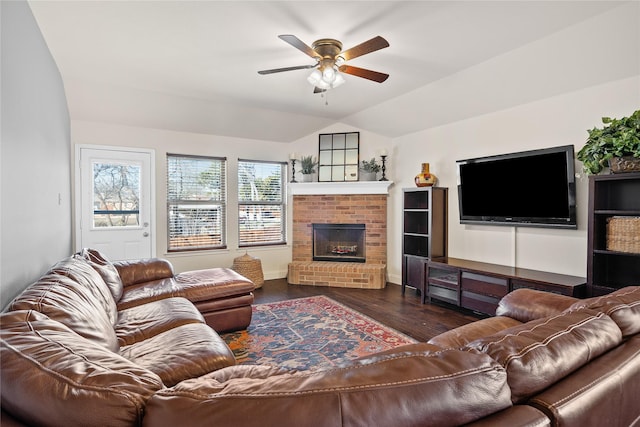 living room with a fireplace, dark wood-type flooring, ceiling fan, and vaulted ceiling