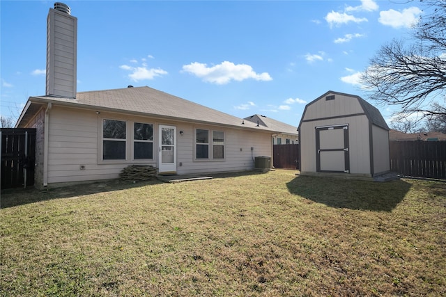 back of property featuring a yard, central AC, and a shed