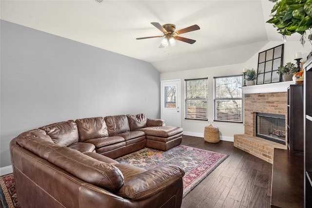 living room featuring dark wood-type flooring, ceiling fan, lofted ceiling, and a brick fireplace