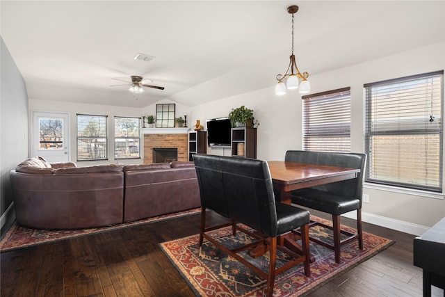 dining area with dark hardwood / wood-style flooring, ceiling fan with notable chandelier, and lofted ceiling