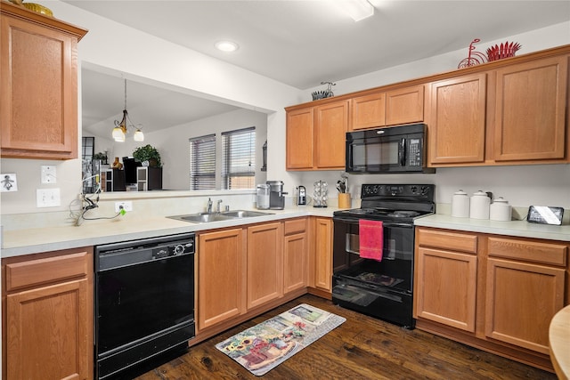 kitchen with dark wood-type flooring, sink, a chandelier, pendant lighting, and black appliances