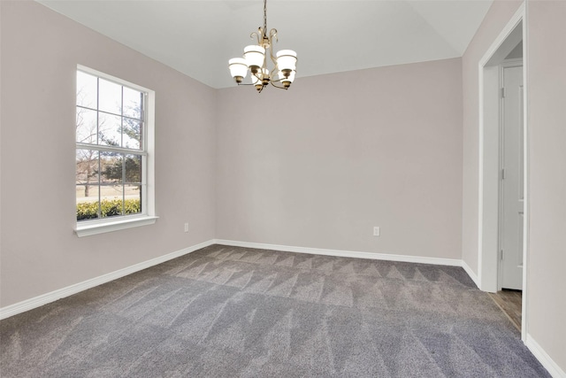 spare room with an inviting chandelier, a wealth of natural light, and carpet