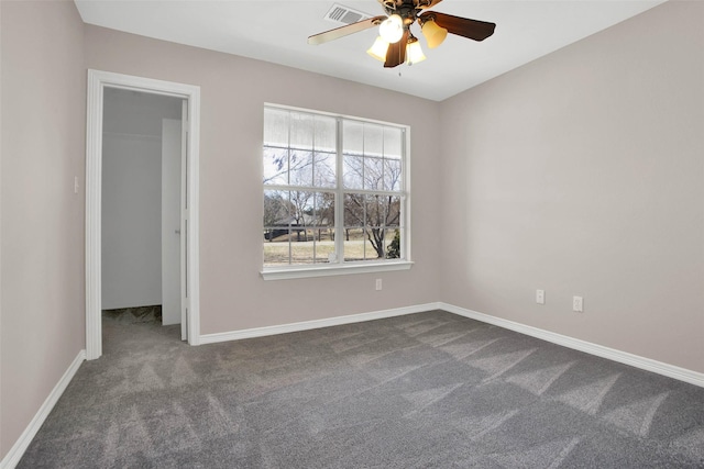 empty room featuring ceiling fan, visible vents, baseboards, and dark colored carpet