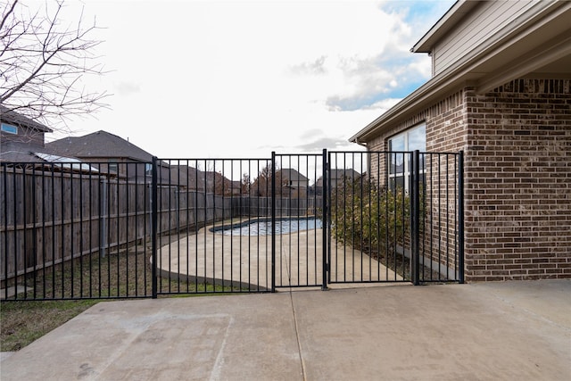 view of gate featuring a patio area