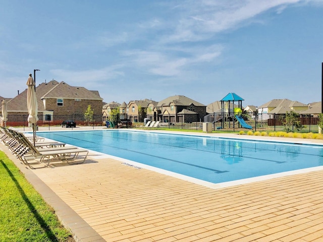 view of swimming pool featuring a playground and a patio area