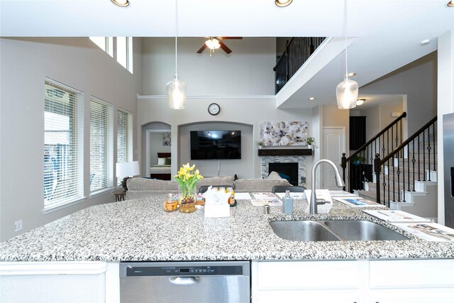 kitchen featuring a breakfast bar area, white cabinetry, hanging light fixtures, stainless steel appliances, and a kitchen island with sink