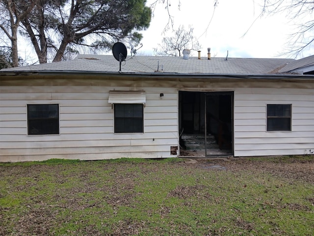 rear view of house featuring a lawn