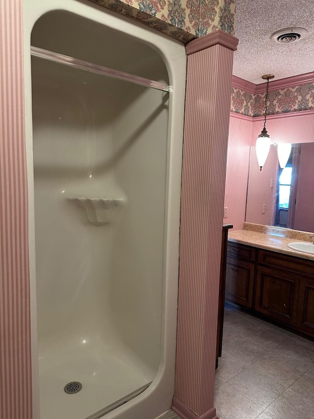 bathroom with walk in shower, vanity, and a textured ceiling