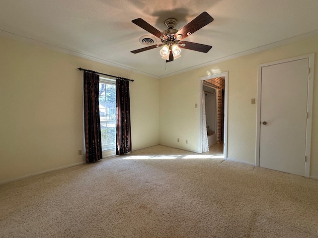 spare room with ceiling fan, light colored carpet, and ornamental molding