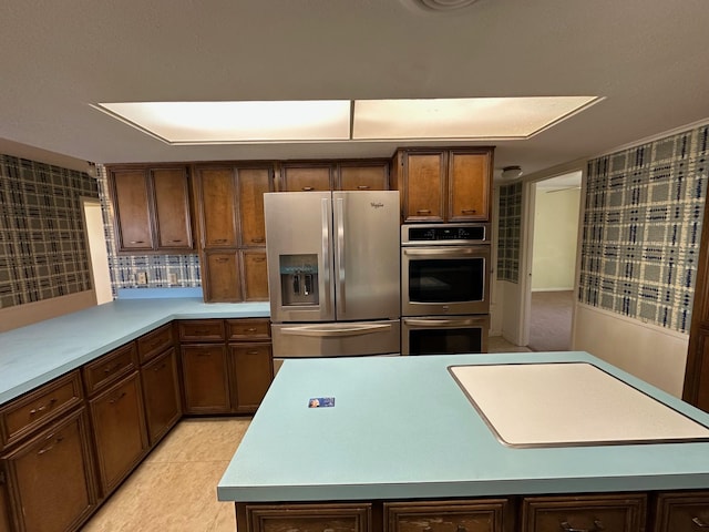 kitchen featuring appliances with stainless steel finishes, a kitchen island, and light tile patterned floors