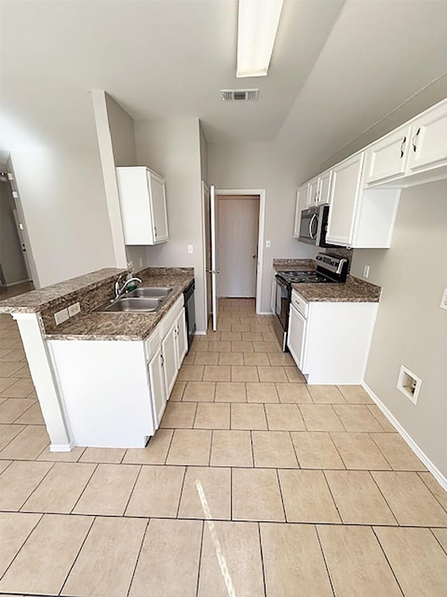 kitchen featuring sink, white cabinetry, dark stone countertops, appliances with stainless steel finishes, and kitchen peninsula