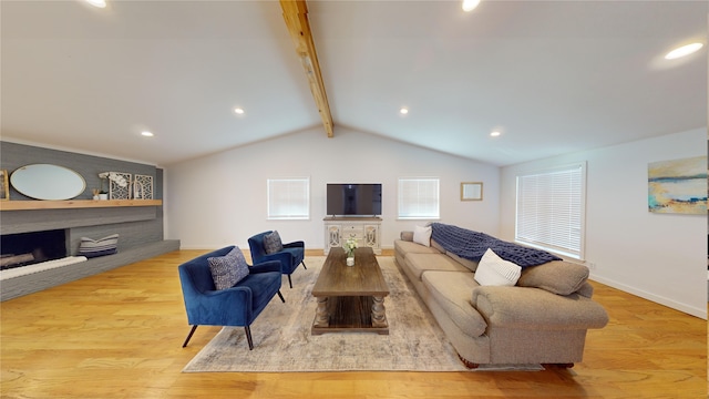 living room featuring vaulted ceiling with beams, a fireplace, and light hardwood / wood-style flooring