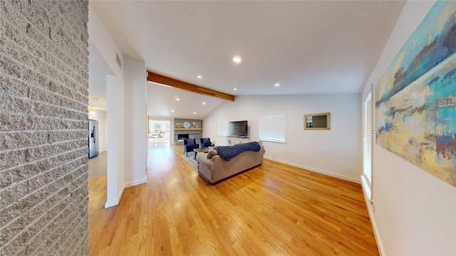 living room featuring vaulted ceiling with beams and light hardwood / wood-style floors