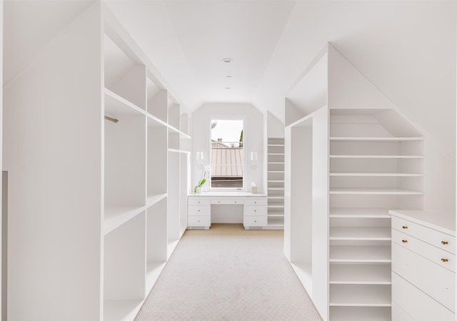 walk in closet featuring vaulted ceiling and light colored carpet