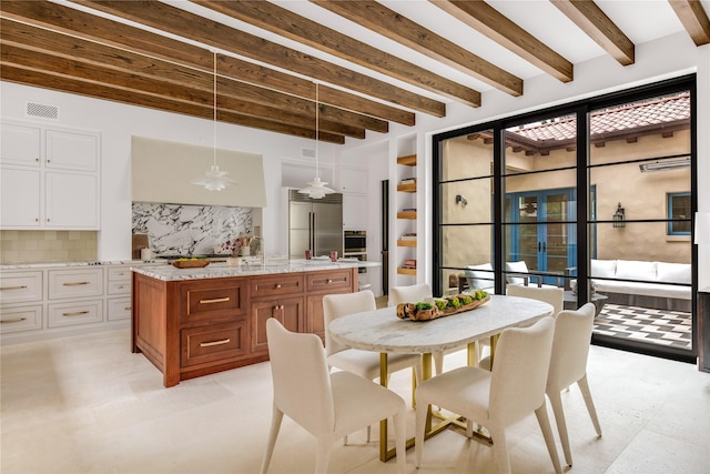 dining space featuring beamed ceiling