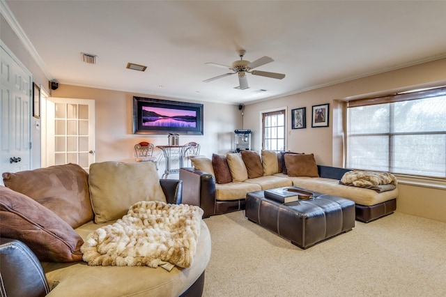 living room with carpet floors, ornamental molding, and ceiling fan