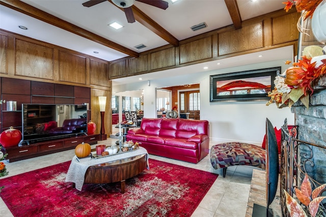 interior space with ceiling fan, beamed ceiling, and wood walls