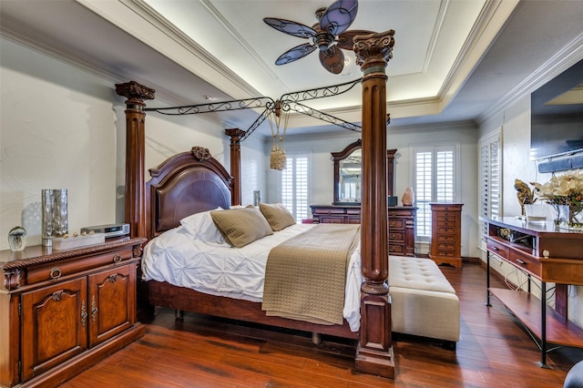 bedroom with a raised ceiling, ceiling fan, crown molding, and dark hardwood / wood-style flooring