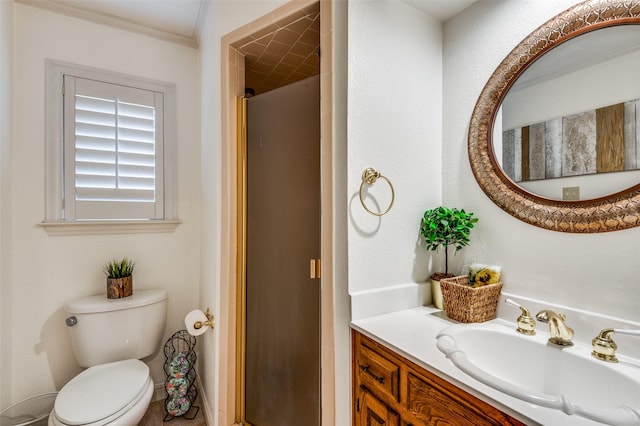 bathroom featuring ornamental molding, toilet, a shower with shower door, and vanity