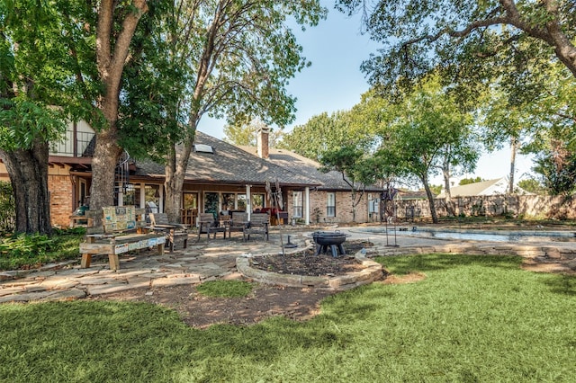 rear view of house with a fenced in pool, a yard, and a patio area