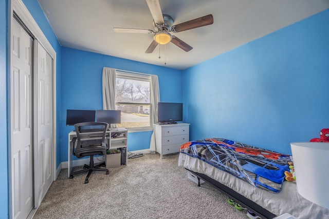 bedroom with light colored carpet, ceiling fan, and a closet