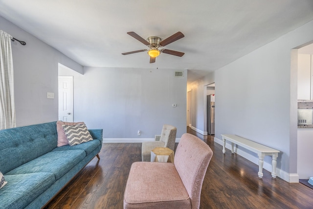 living room featuring dark wood-type flooring and ceiling fan