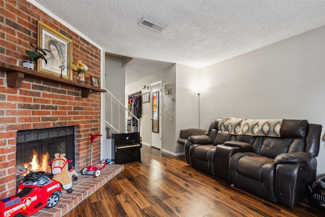 living room with a fireplace, dark hardwood / wood-style floors, and a textured ceiling