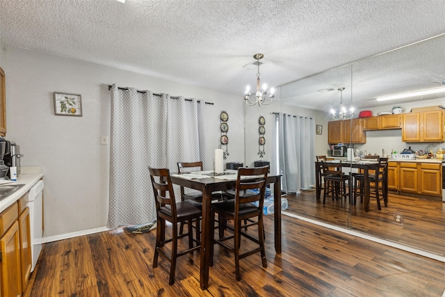 dining space featuring dark hardwood / wood-style floors, a notable chandelier, and a textured ceiling