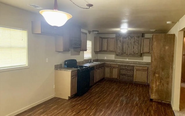 kitchen featuring sink, dark hardwood / wood-style floors, stainless steel dishwasher, and gas stove