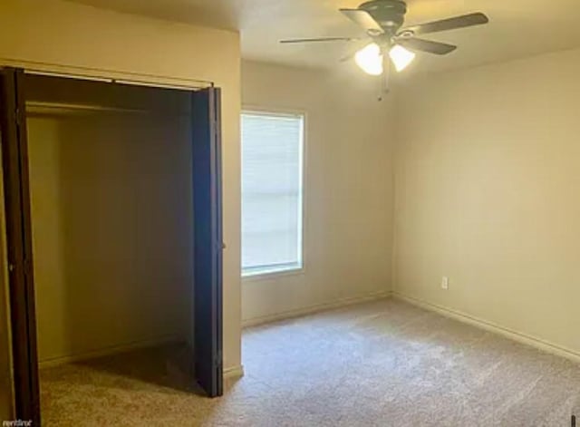 unfurnished bedroom with ceiling fan, a closet, and light carpet