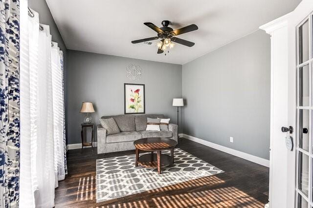 living room featuring ceiling fan and dark hardwood / wood-style flooring