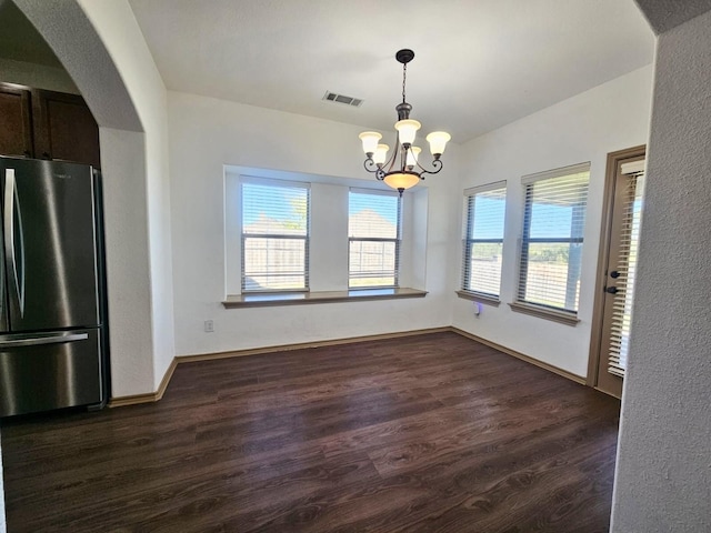 unfurnished dining area with a notable chandelier and dark hardwood / wood-style flooring