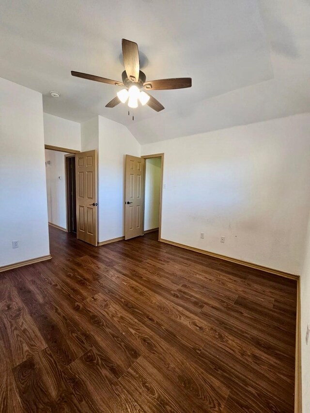 unfurnished room featuring dark hardwood / wood-style flooring, vaulted ceiling, and ceiling fan