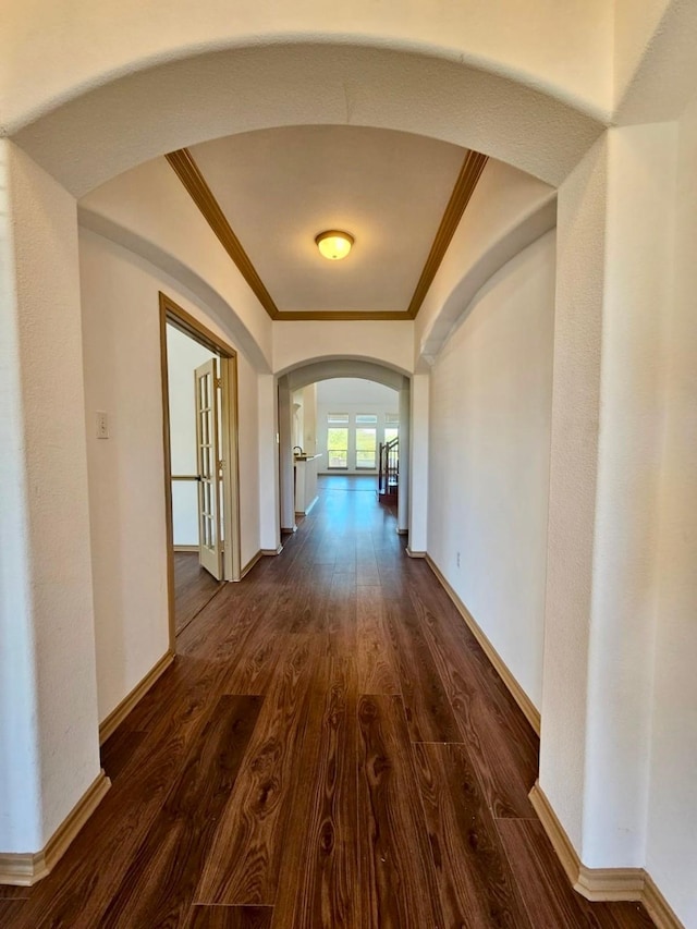 corridor with ornamental molding, dark hardwood / wood-style floors, and french doors