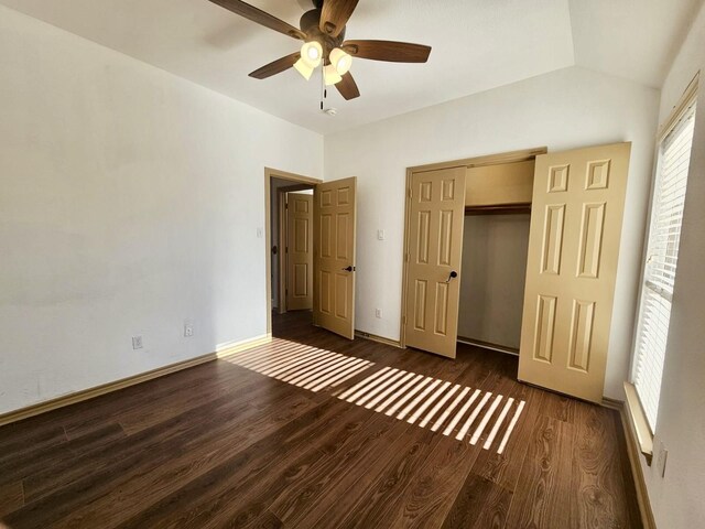 unfurnished bedroom featuring dark wood-type flooring, a closet, ceiling fan, and vaulted ceiling