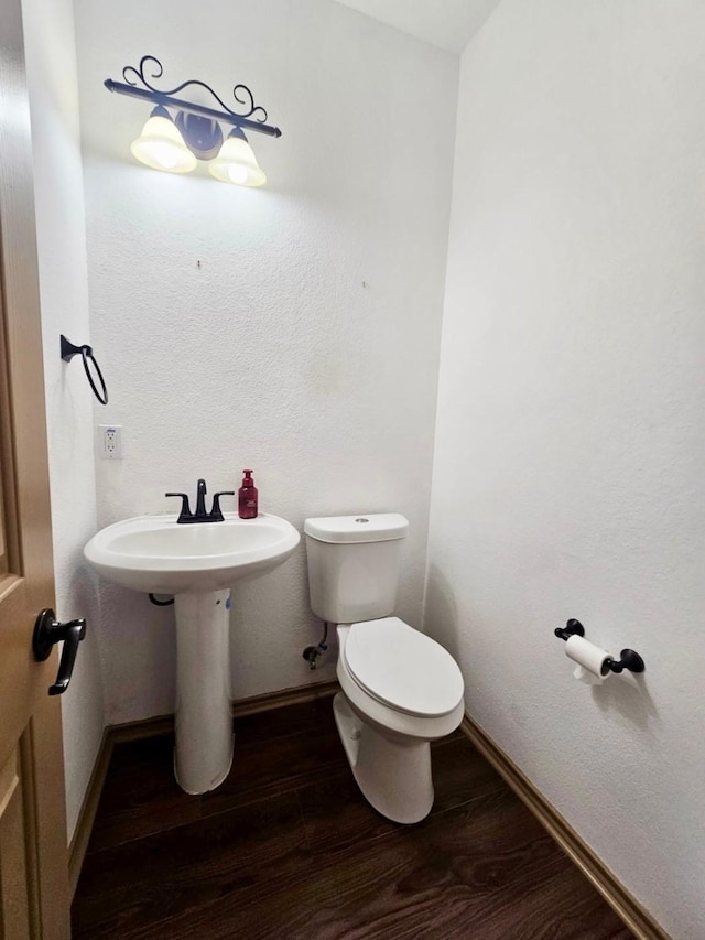 bathroom with toilet and hardwood / wood-style floors