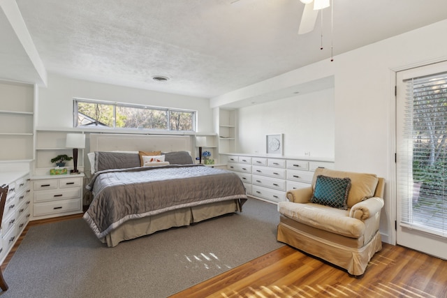 bedroom with a textured ceiling, light hardwood / wood-style flooring, ceiling fan, and access to outside