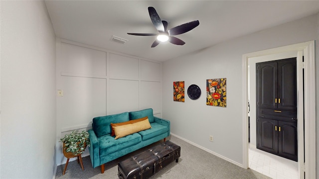 living area with carpet floors and ceiling fan