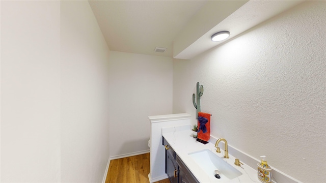 bathroom with vanity, hardwood / wood-style flooring, and toilet