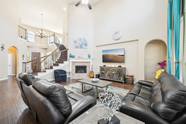 living room with an inviting chandelier, hardwood / wood-style flooring, a fireplace, and a high ceiling