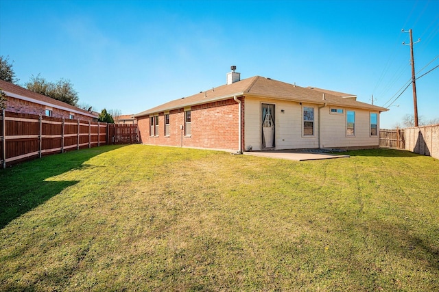 rear view of house featuring a yard and a patio area