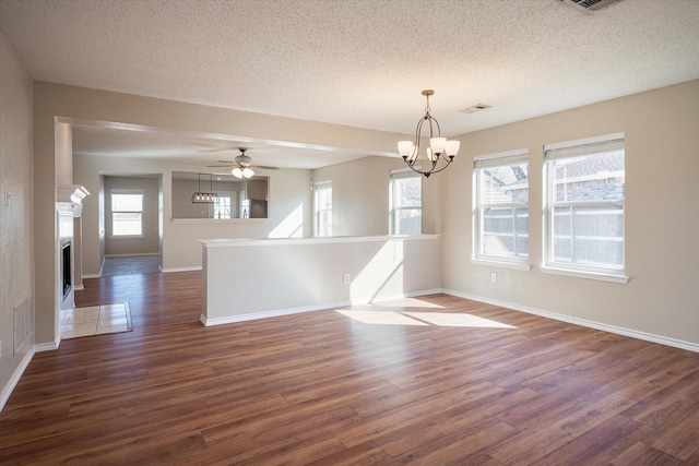 unfurnished room featuring dark hardwood / wood-style floors, ceiling fan with notable chandelier, and a textured ceiling