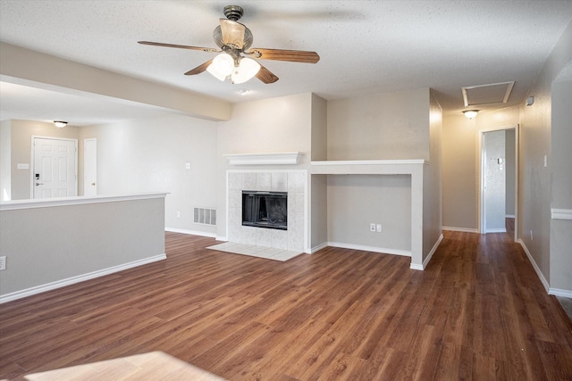 unfurnished living room featuring a textured ceiling, a fireplace, and dark hardwood / wood-style flooring