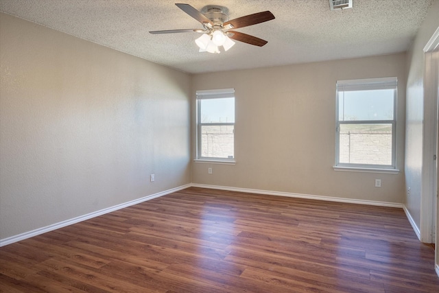 spare room featuring ceiling fan, dark hardwood / wood-style floors, and a textured ceiling